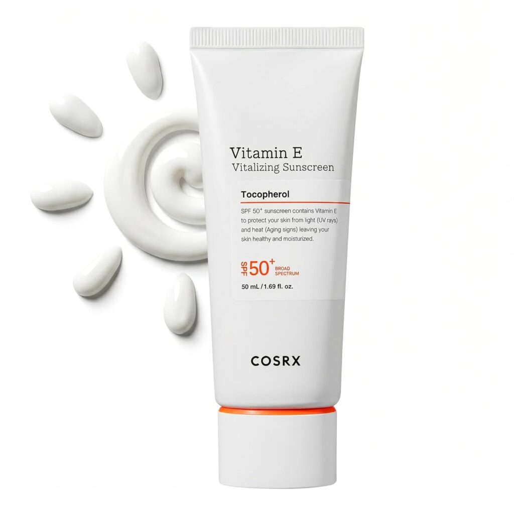 a tube of COSRX Vitamin E Sunscreen beside a clear, lightweight swatch.
